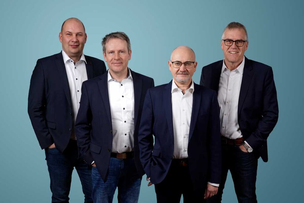 Foto der Geschäftsleitung mit vier Personen in dunklem Anzug.